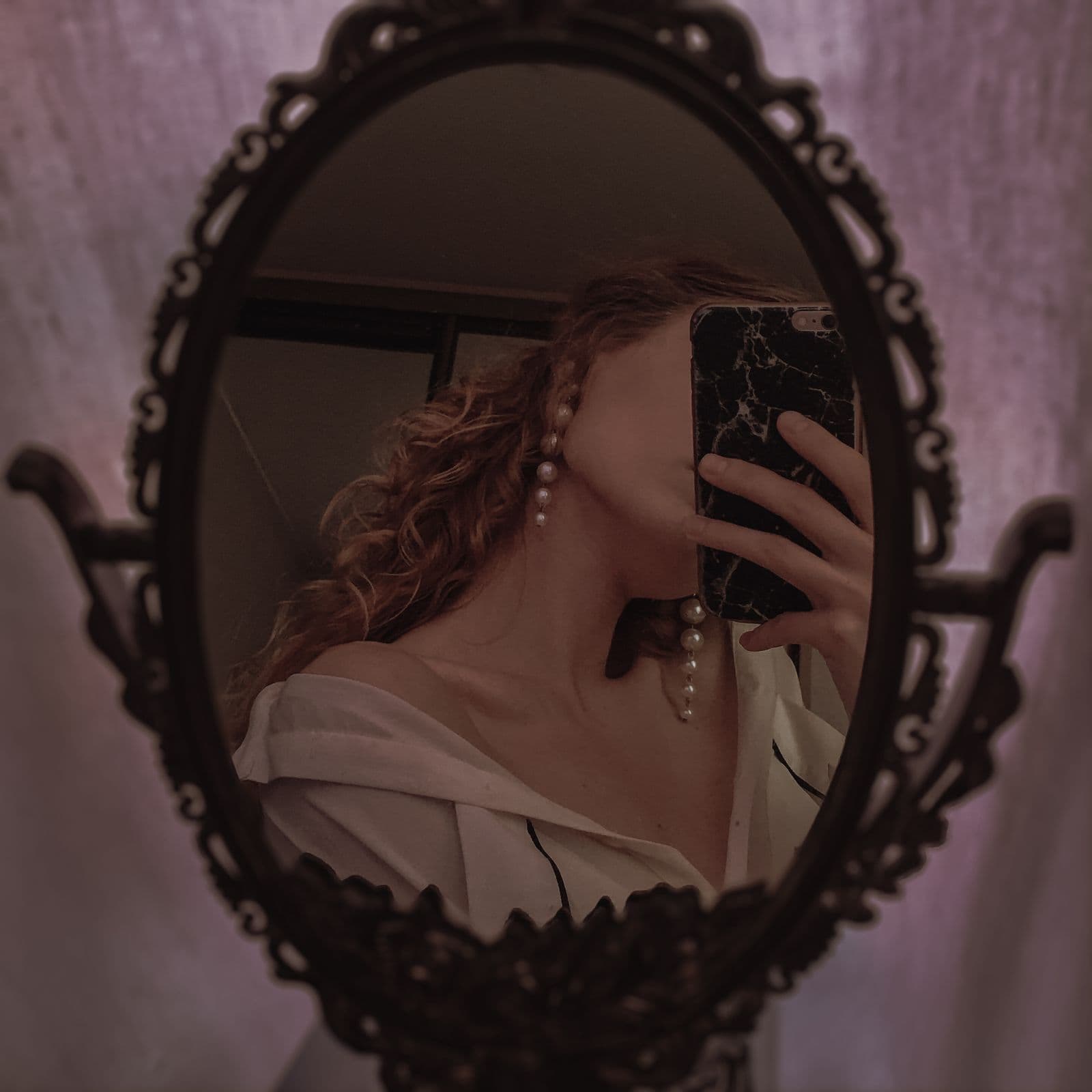 A woman taking a mirror selfie, her phone hiding her face